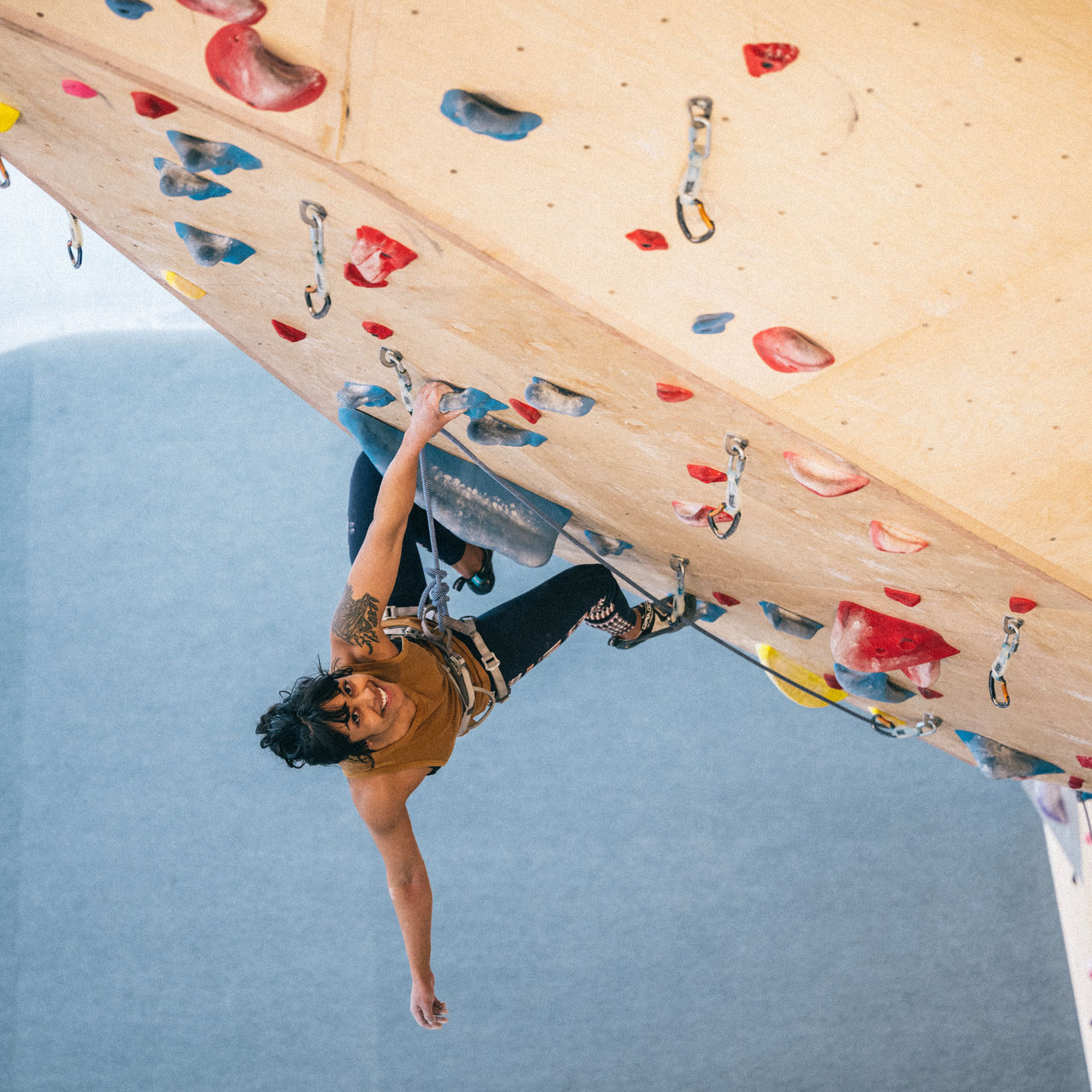 A lead climber on an indoor rock wall