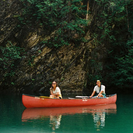 Haley Toy and Gary Huey smile from a canoe