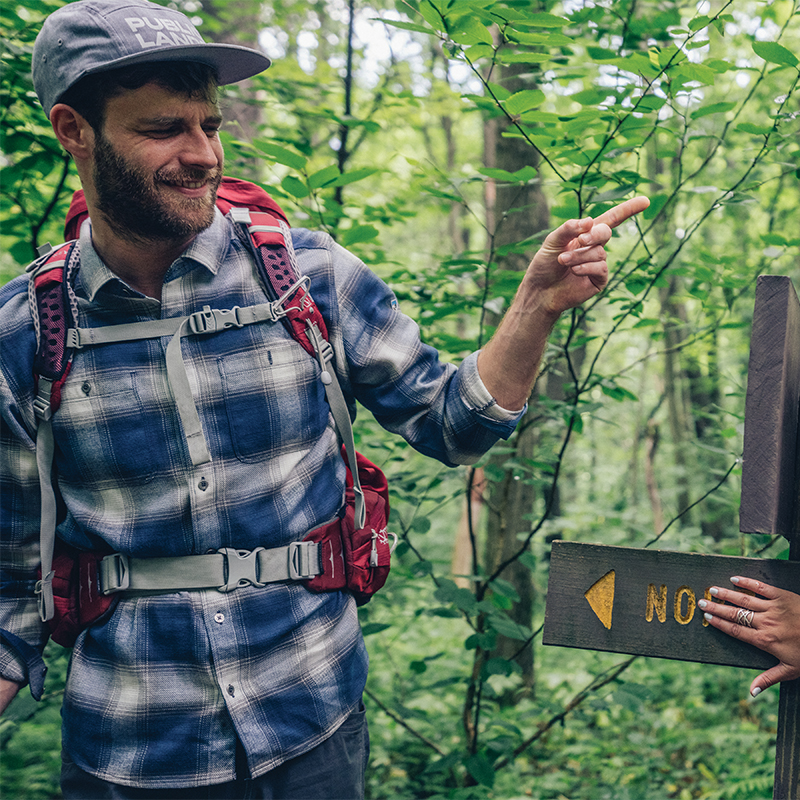 Hiker having fun on a trail  pointing which way to go