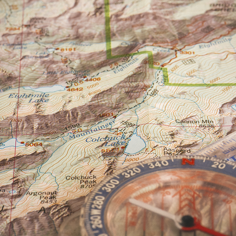 A detail of a topographic map with a compass