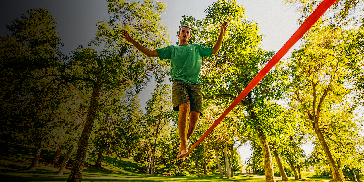 A man slacklining in a park in Bozeman, Montana.