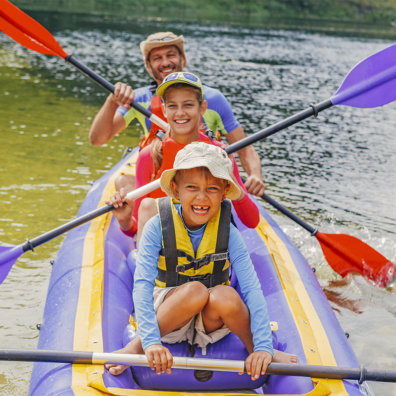A family inflatable kayaking on a river