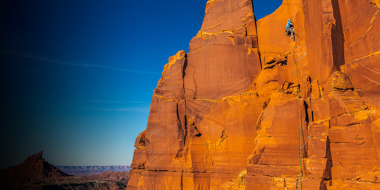 A climber on the popular South Face (5.7) tradroute on South Sixshooter tower in Utah's Indian Creek.