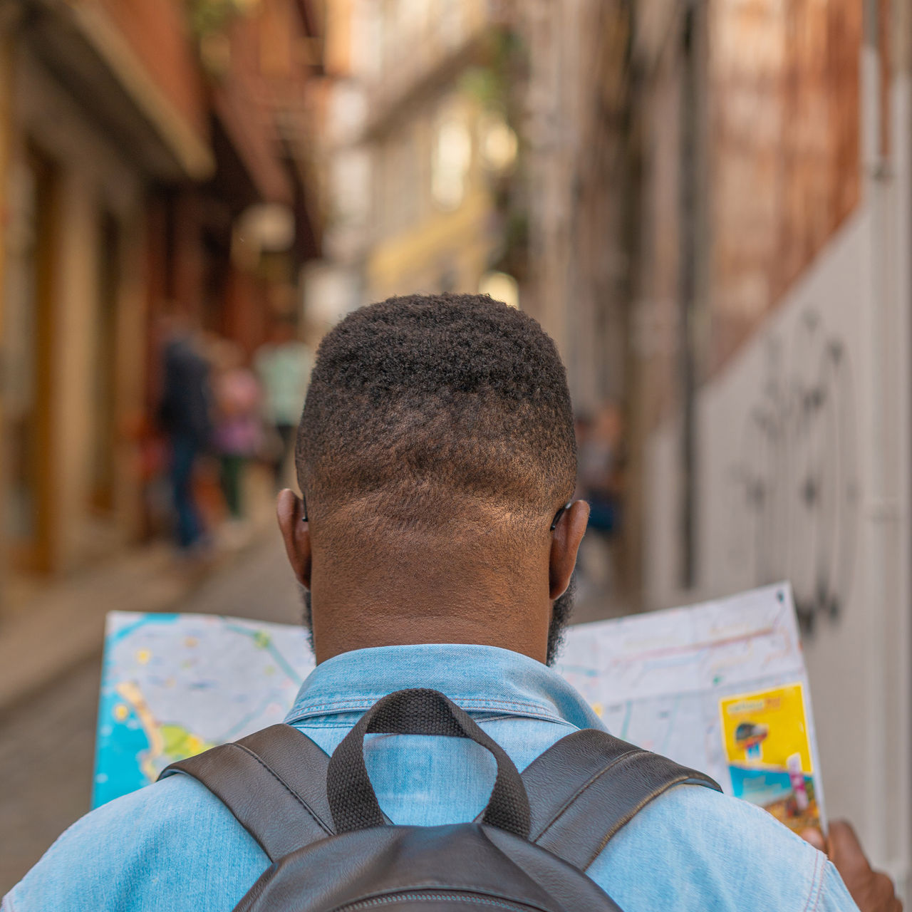 Tourist man looking at map to find directions walking in old streets of Portugal city. 