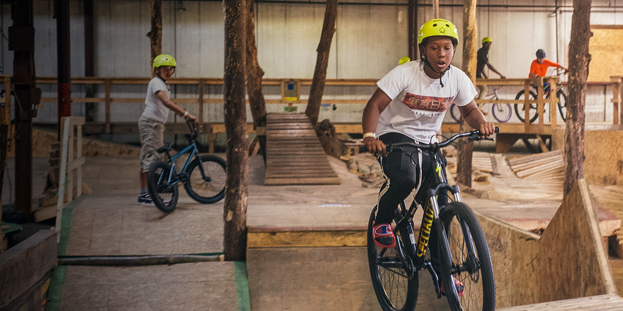 A boy rides a mountain bike at a mountain bike park