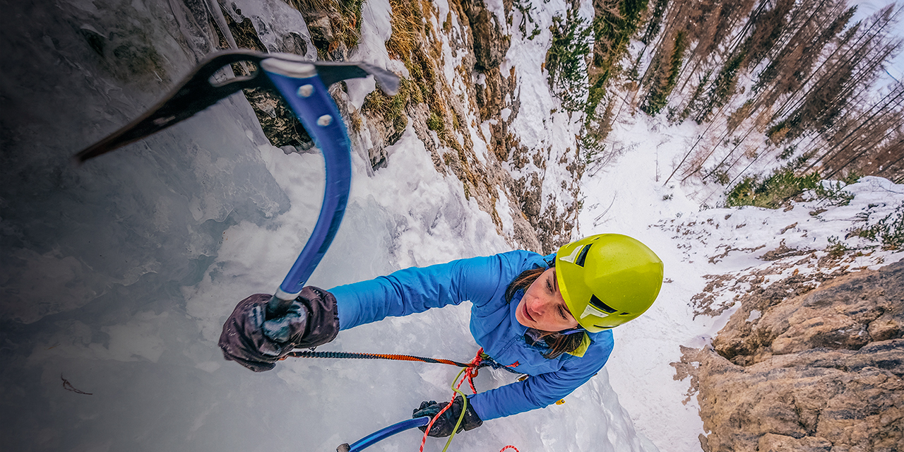 A woman uses an ice axe while ice climbing