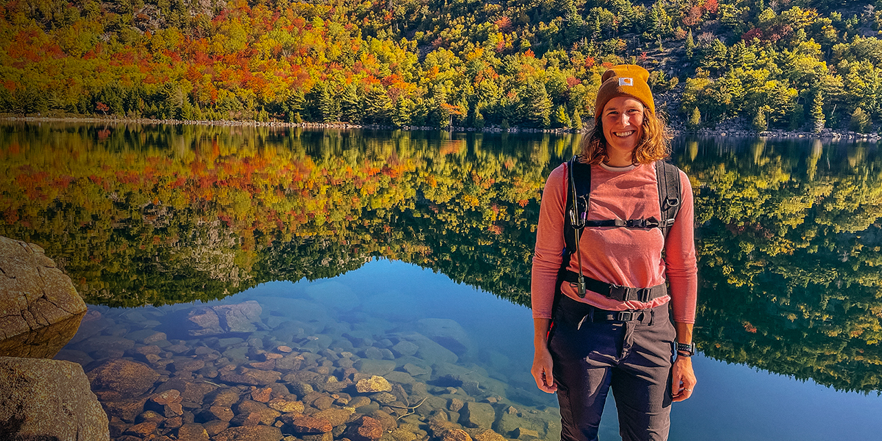 Sarah Brown poses in front of a lake in the fall