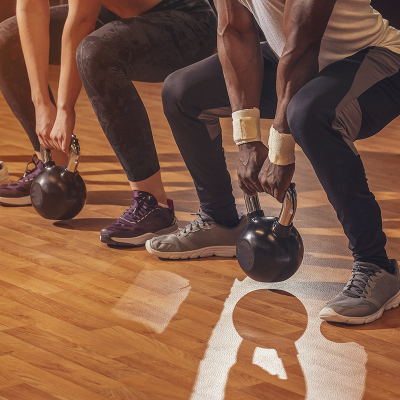 People using kettlebells in squats 