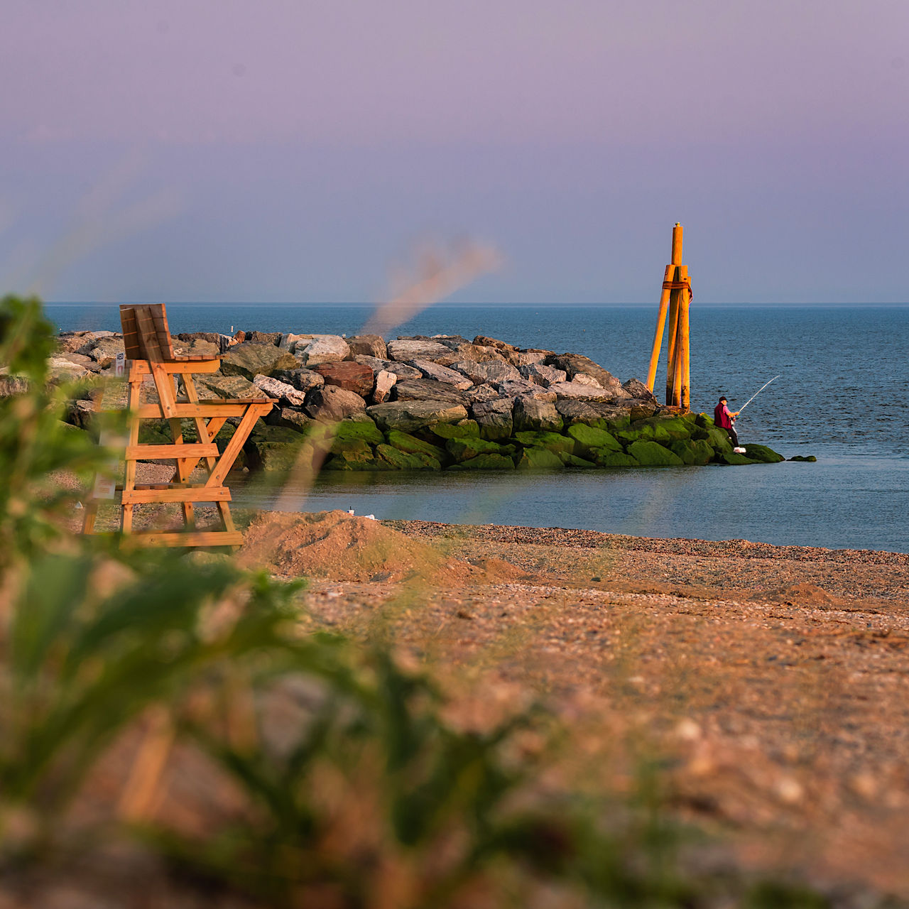 A morning view of Cedar beach, Mt Sinai, NY,   in the morning with iconic stone wall and wood light tower. 