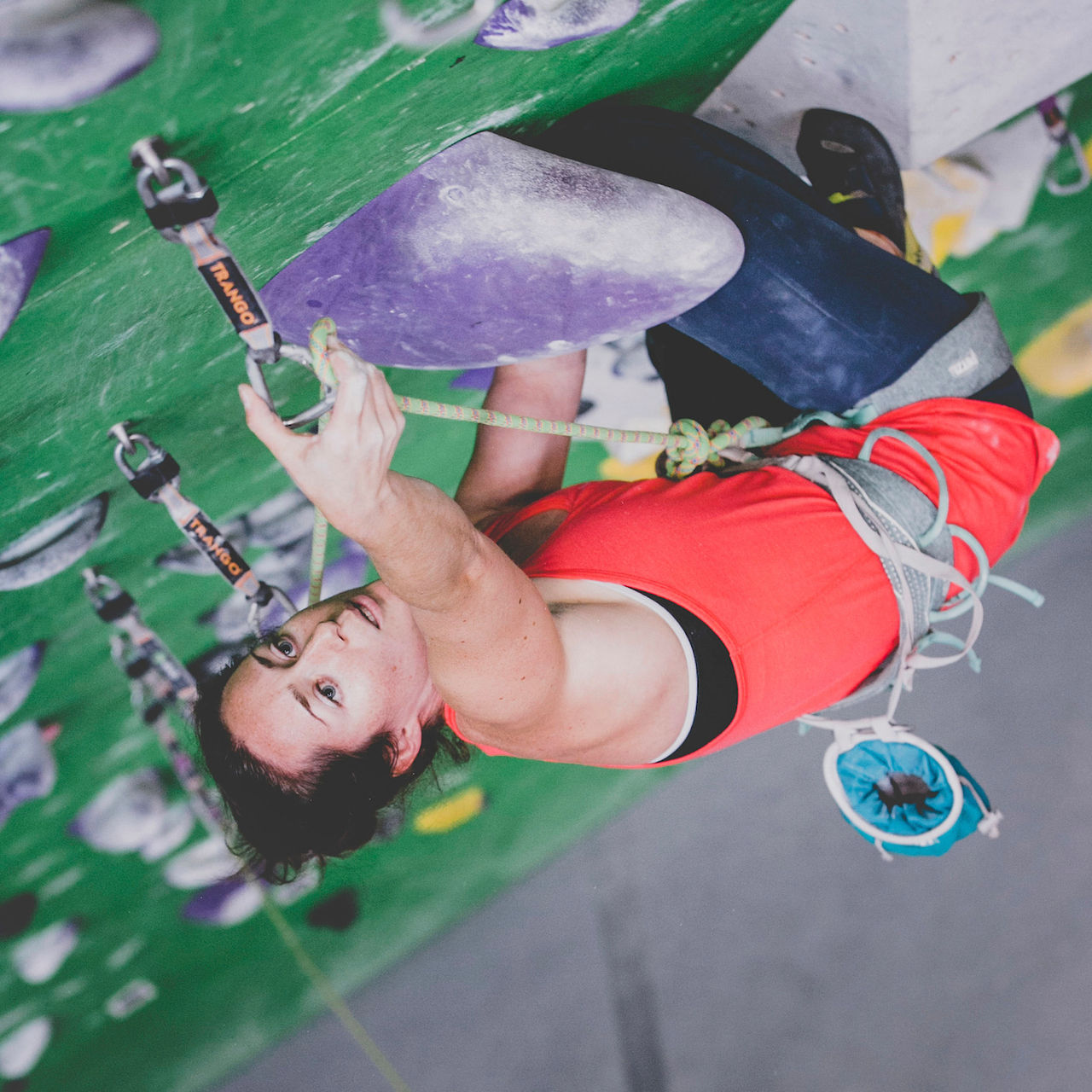 Mo Beck climbs on an indoor rock wall