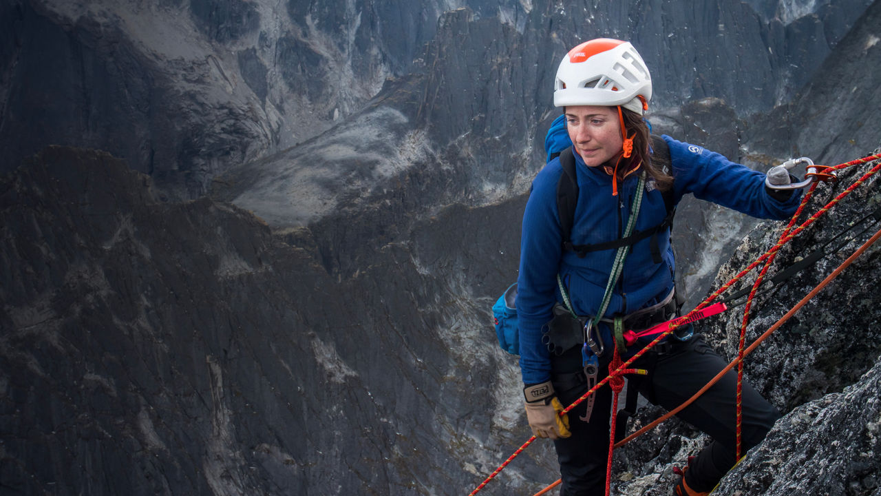 Mo Beck looks on as she rock climbs