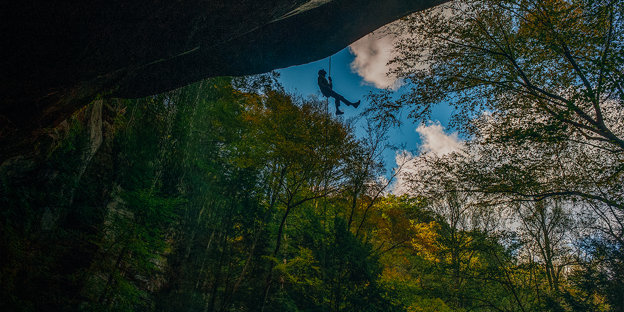 A person rappels Big Spring Hollow Waterfall 