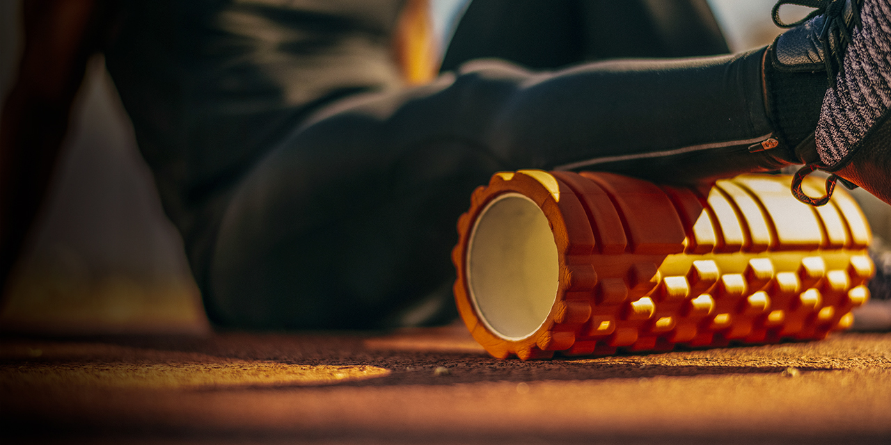 A person uses a foam roller on their leg