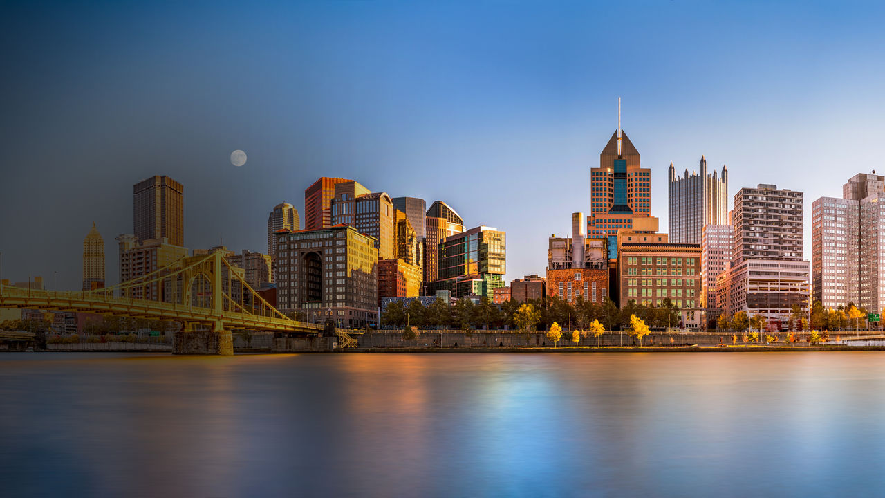 Long exposure of Pittsburgh downtown skyline and Roberto Clemente bridge, on a sunny afternoon, as viewed from North Shore Riverfront Park, across Allegheny River. 