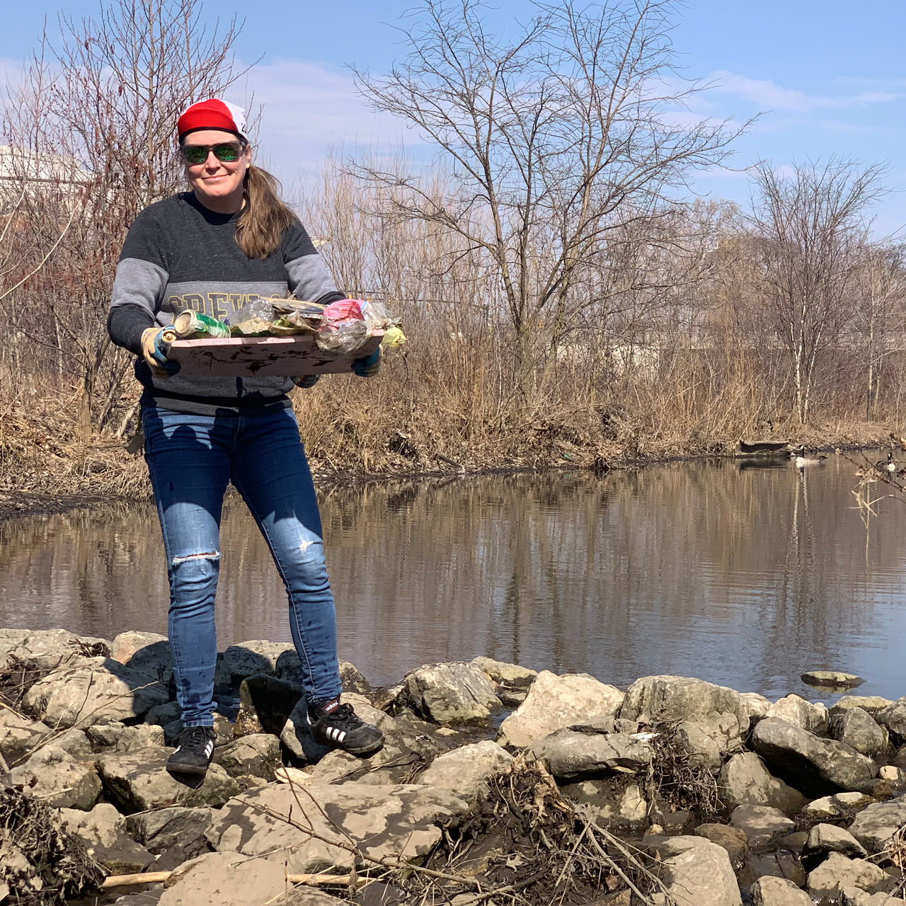 A woman poses with cleanup debris during a FLOW event