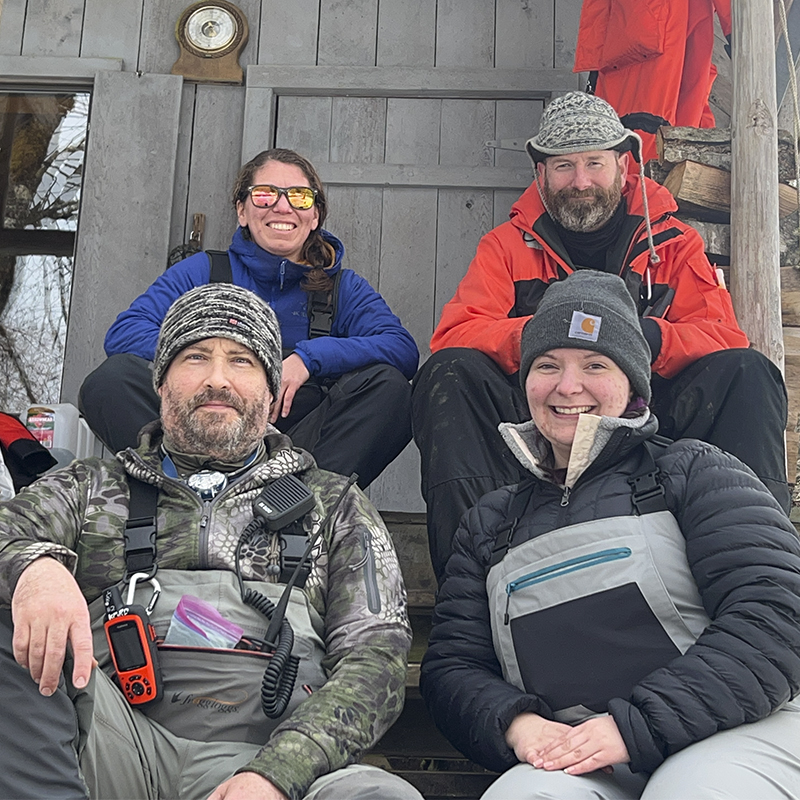 Team members pose as they collect EDNA water samples on the Jóonax (Unuk) River