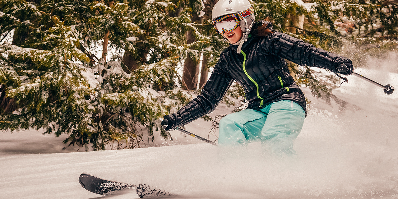 A woman skiing down a mountain