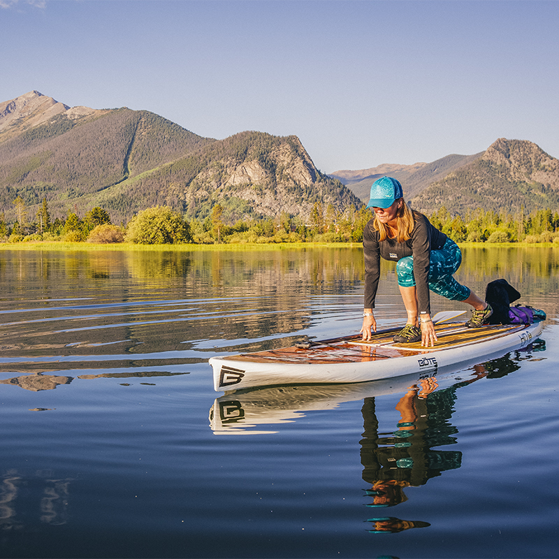 A female paddlboarder on Lake Dillon in Summit County, Colorado in the early morning.