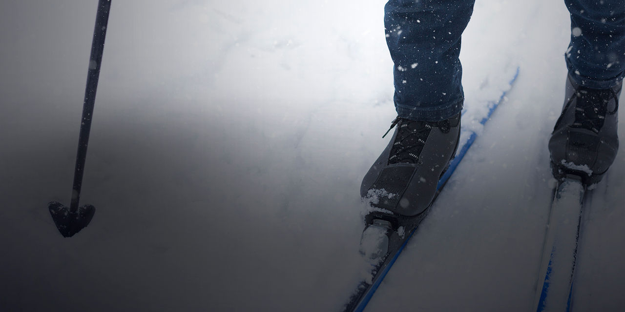 Feet of a skier in ski boots on cross-country skis. Walking in the snow, winter sports, healthy lifestyle. Close-up, copyspace, Feet of a skier in ski boots on cross-country skis. Walking in t