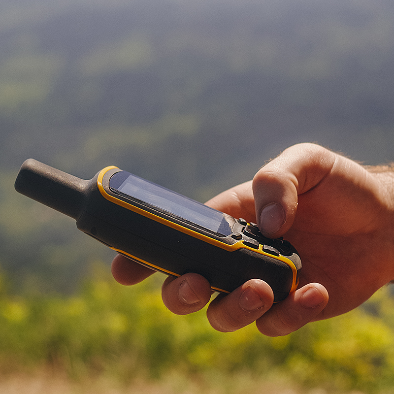 A person checks their satellite messenger