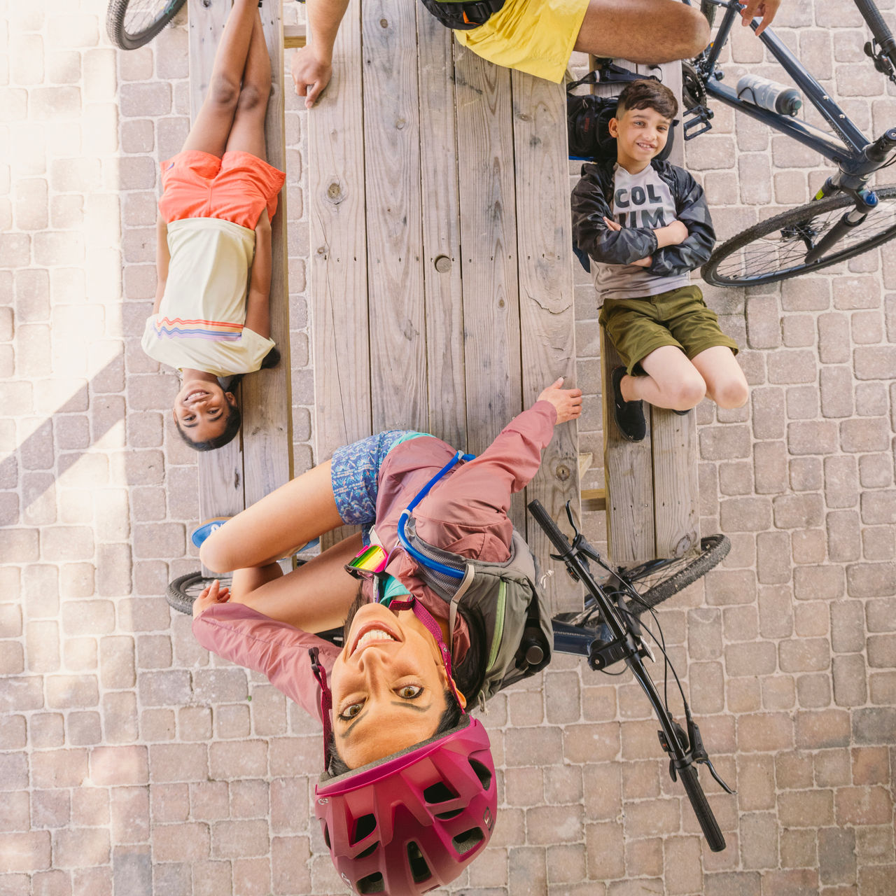A parent and kids with bikes looks up