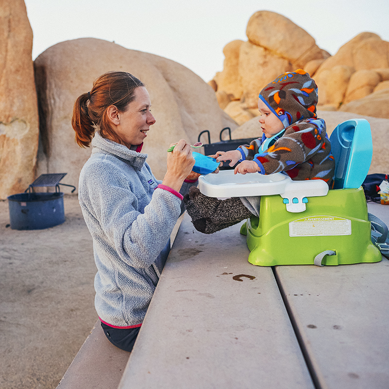 Woman feeding her baby at a campsite in Joshua Tree