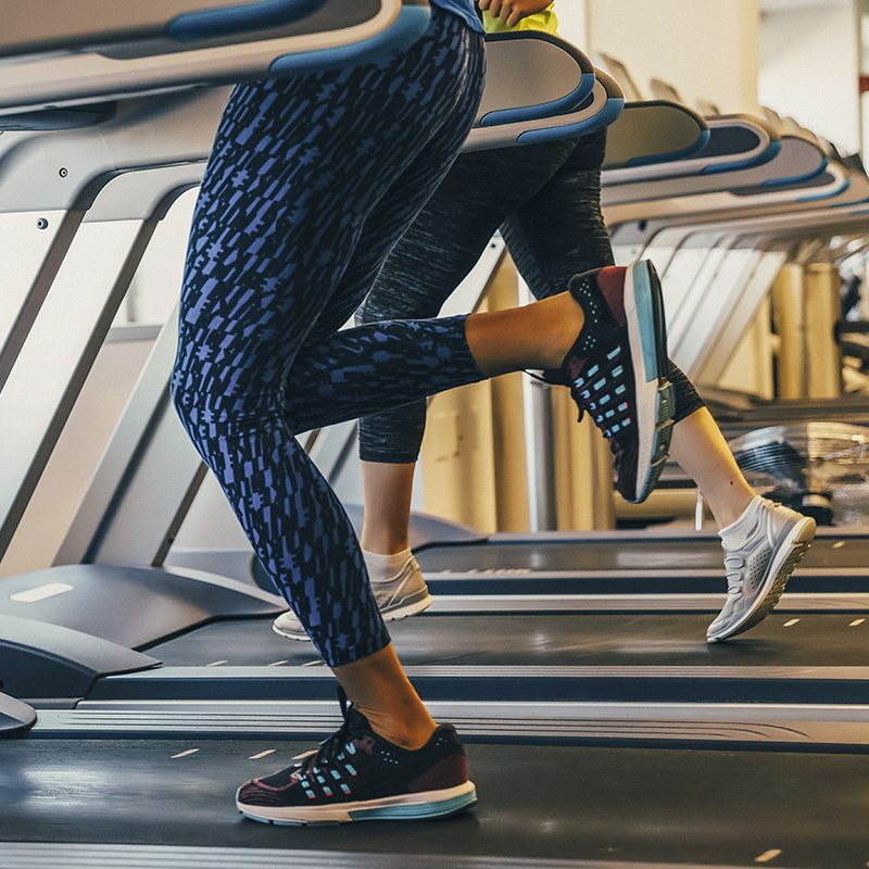 An image of women's legs running on a treadmill