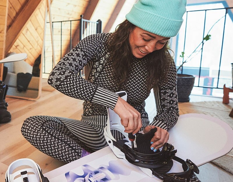 Female Snowboarder wearing a jacket, base layer, goggles and helmet in the snow